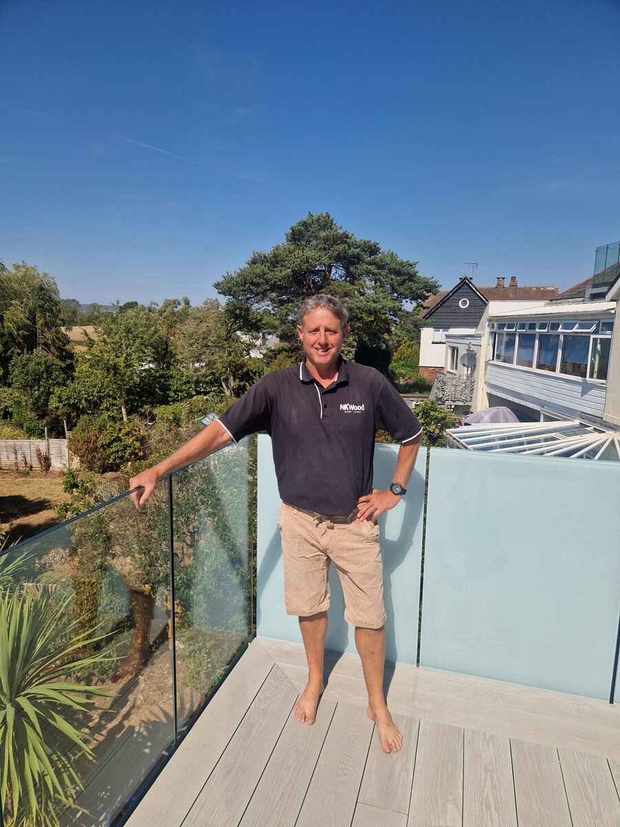 Nigel, founder of NK Wood, on a finished balcony and decking job